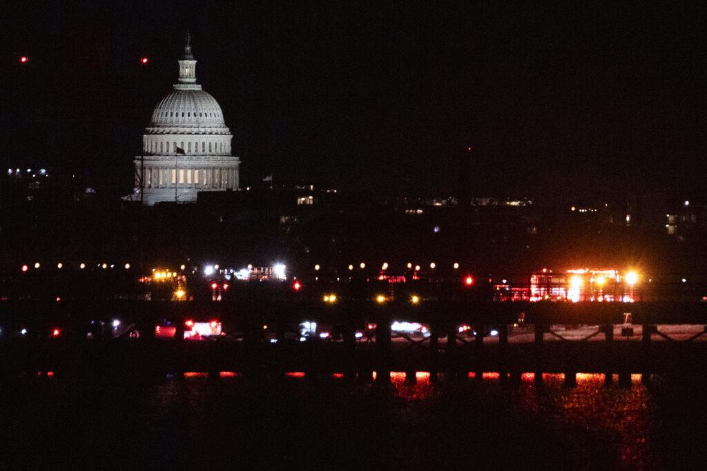 29.01.2025, USA, Alexandria: Notfallfahrzeuge stehen am Ronald Reagan Washington National Airport. Das US-Kapitol ist auf der anderen Seite des Potomac River in Washington zu sehen. Foto: Kevin Wolf/AP/dpa +++ dpa-Bildfunk +++