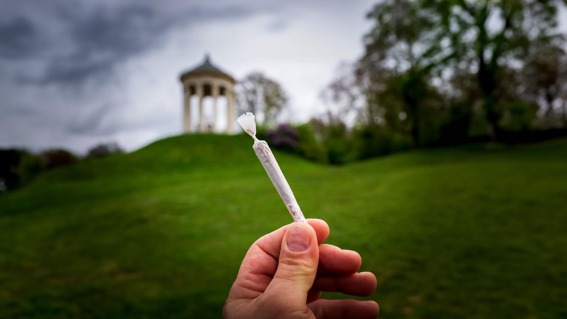 Ein Cannabis-Joint vor dem Monopteros im Englischen Garten in München.