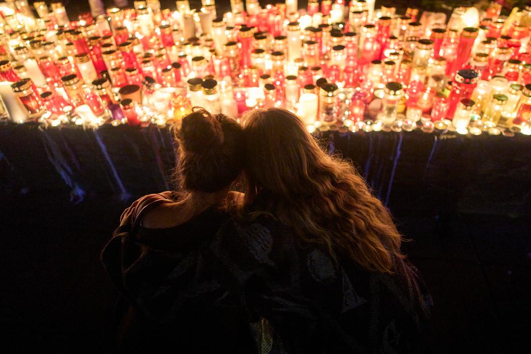 Zwei Frauen schauen auf Kerzen für die Opfer eines Amoklaufs an einer Schule in Graz.