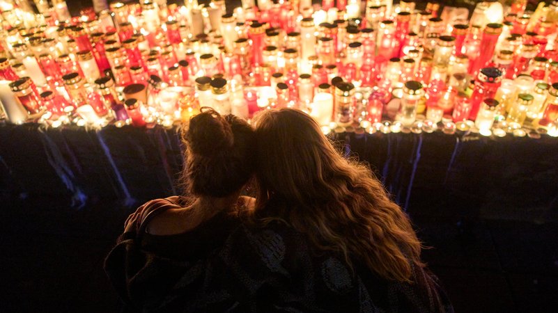 Zwei Frauen schauen auf Kerzen für die Opfer eines Amoklaufs an einer Schule in Graz. | Bild: dpa-Bildfunk/Darko Bandic Zwei Frauen schauen auf Kerzen für die Opfer eines Amoklaufs an einer Schule in Graz.