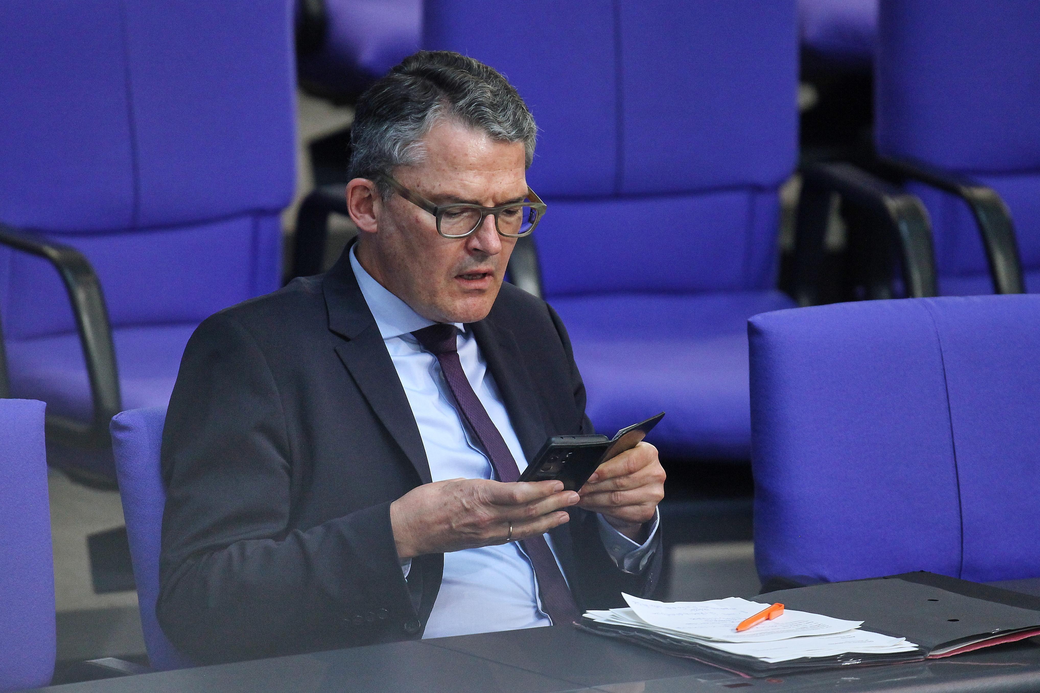 Roderich Kiesewetter, CDU, schaut im Bundestag auf sein Handy.