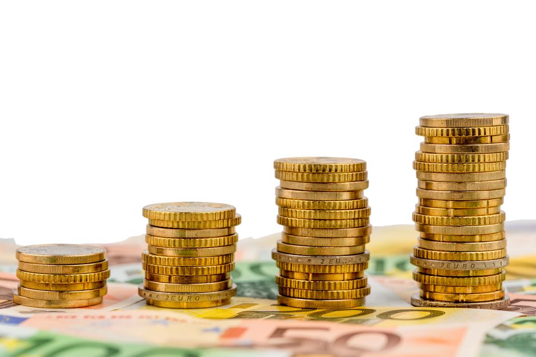 Gestapelte Euro-Münzen auf Geldscheinen.