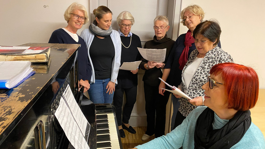 Singen hilft Long Covid-Patienten. Die Selbsthilfegruppe singt jede Woche in Augsburg, in den Räumen der Evang.-Luth. Gemeinde St. Anna, unter der Leitung von Gesangslehrerin Elisabeth Haumann (am Klavier) Initiatorin Claudia Stöhler ist eine Macherin, die anpackt (3. von rechts).