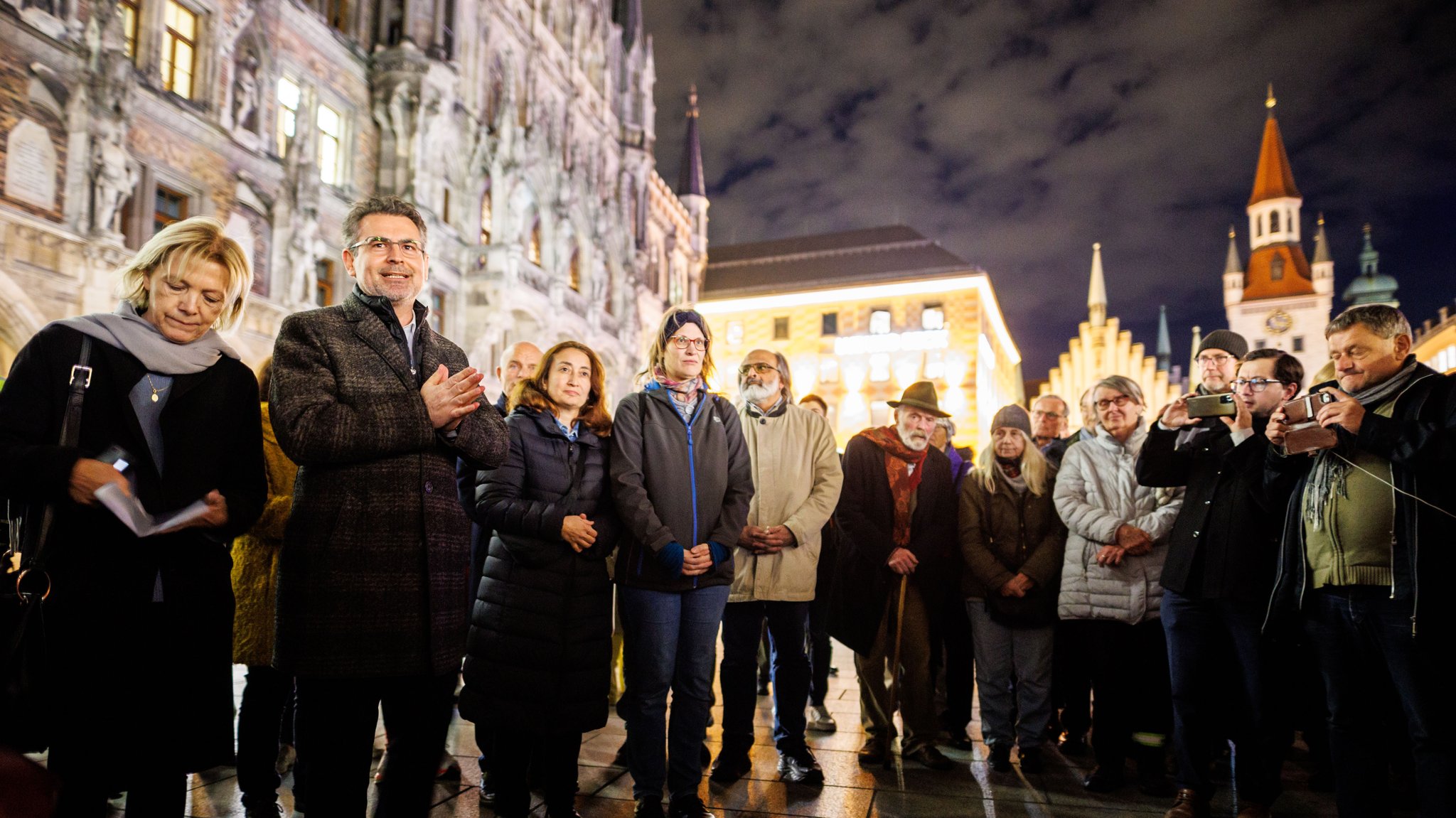 Imam Benjamin Idriz (2. v. l.) spricht zu einer Gruppe von Menschen auf dem Marienplatz, nachdem das Friedensgebet kurz zuvor abgesagt wurde.