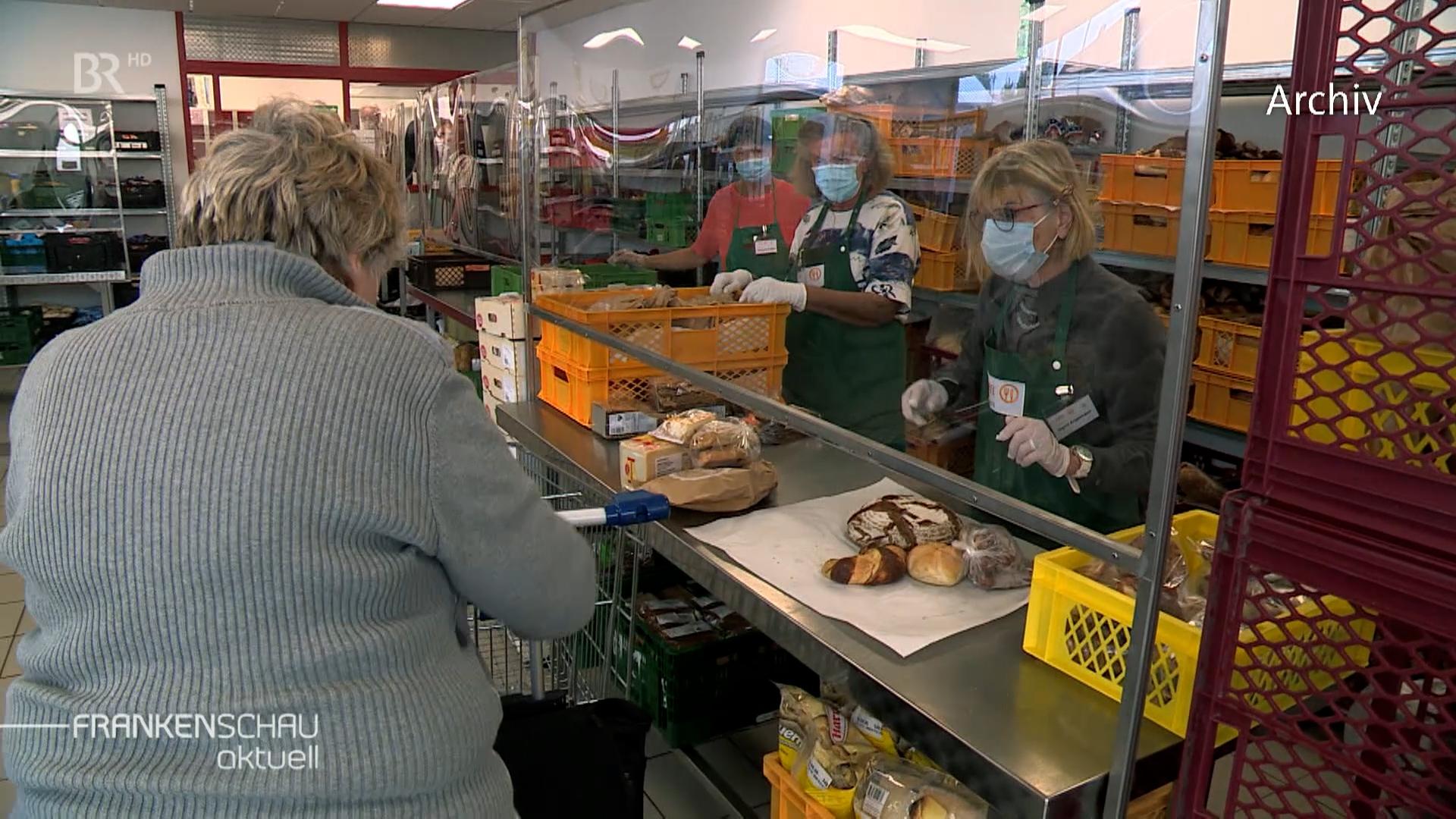 Helferinnen der Tafel geben Essen aus. 