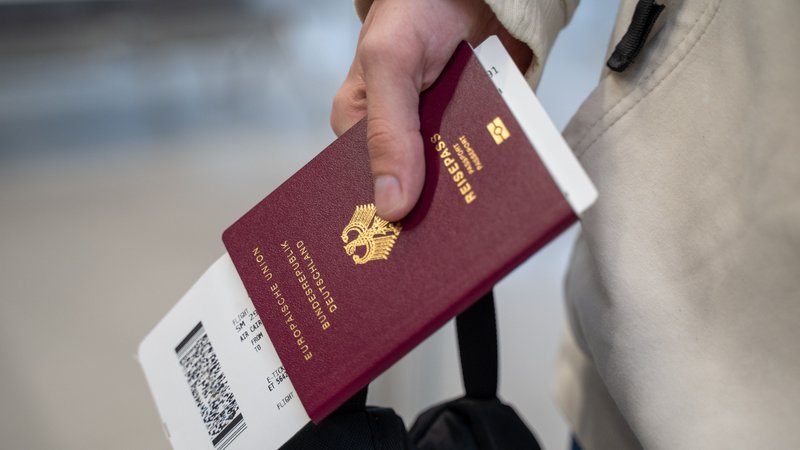 Ein biometrischer Reisepass und ein Flugticket in der Hand von einem Passagier. | Bild: picture alliance / Eibner-Pressefoto | Eibner-Pressefoto/Jonas Lohrmann Ein biometrischer Reisepass und ein Flugticket in der Hand von einem Passagier.