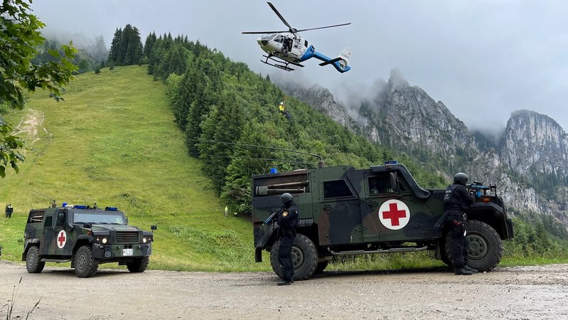Sanitätsfahrzeuge der Bundeswehr und ein Polizei-Hubschrauber während der Übung AlpenTEX  