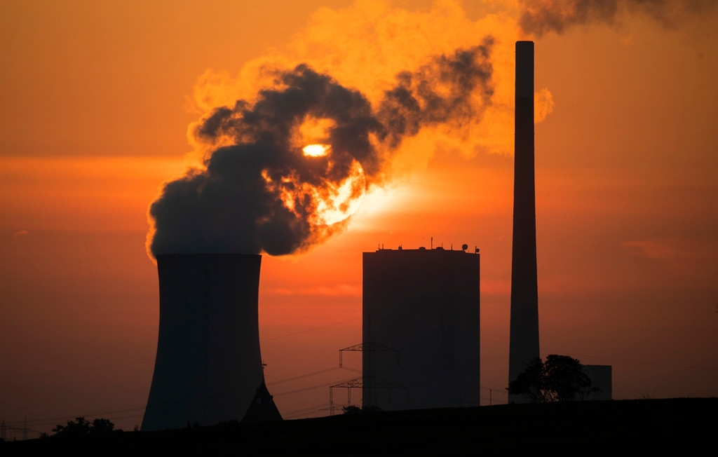 ARCHIV - 19.08.2020, Niedersachsen, Hohenhameln: Die Sonne geht hinter dem Kohlekraftwerk Mehrum im Landkreis Peine auf
