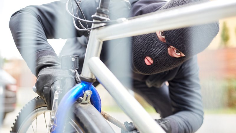 Dieb mit Maske versucht Fahrrad-Kette zu öffnen. | Bild: picture alliance Dieb mit Maske versucht Fahrrad-Kette zu öffnen.