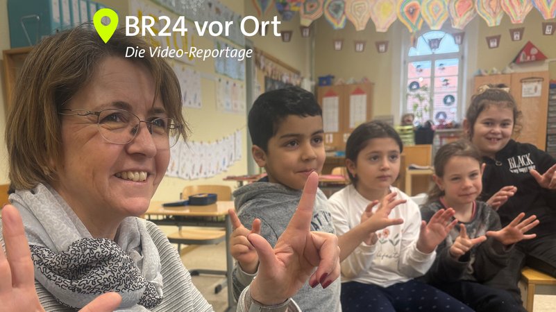Klassenleiterin Tanja Kärpf übt mit ihren Schülerinnen und Schülern der Klasse 1c die Wochentage, die sie mit ihren Fingern abzählen. | Bild: Bayerischer Rundfunk 2025 Klassenleiterin Tanja Kärpf übt mit ihren Schülerinnen und Schülern der Klasse 1c die Wochentage, die sie mit ihren Fingern abzählen.
