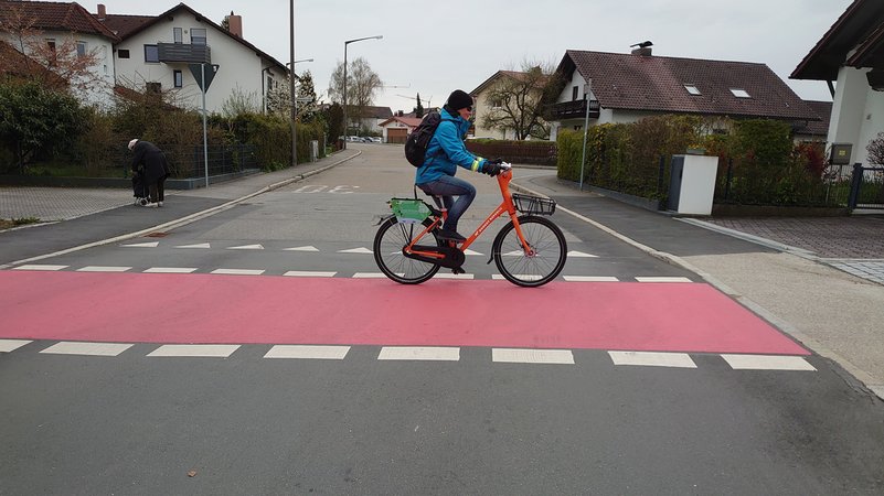 Ein Radfahrer an einer rot markierten Radkreuzung in Straubing
