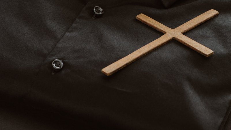 Ein Kreuz liegt auf Pfarrerskleidung. Es ist ein Symbolbild. | Bild: stock.adobe.com/LIGHTFIELD STUDIOS Ein Kreuz liegt auf Pfarrerskleidung. Es ist ein Symbolbild.