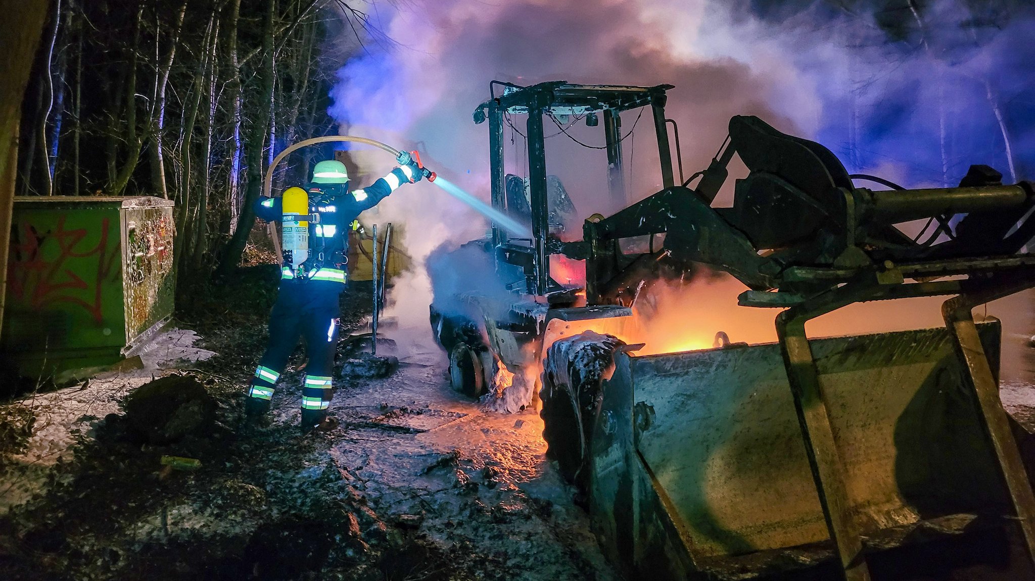 Feuerwehr-Löscharbeiten an dem Radlader.