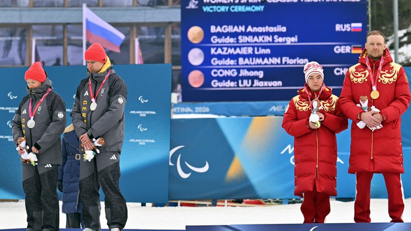 Linn Kazmaier (l) und Guide Florian Baumann (2.v.l) aus Deutschland stehen neben Anastasiia Bagajan (2.v.r). | Bild: picture alliance/dpa | Martin Schutt Linn Kazmaier (l) und Guide Florian Baumann (2.v.l) aus Deutschland stehen neben Anastasiia Bagajan (2.v.r).