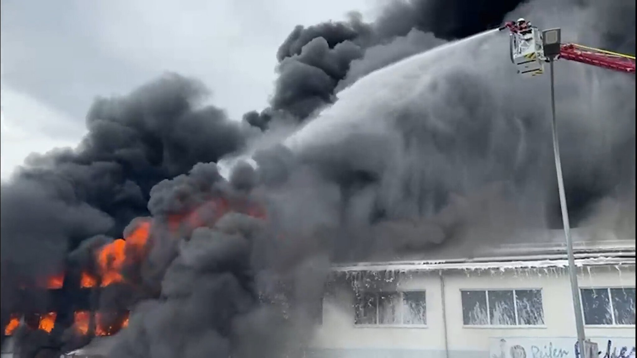 Flammen und dicker schwarzer Rauch. Feuerwehrmann im Einsatz