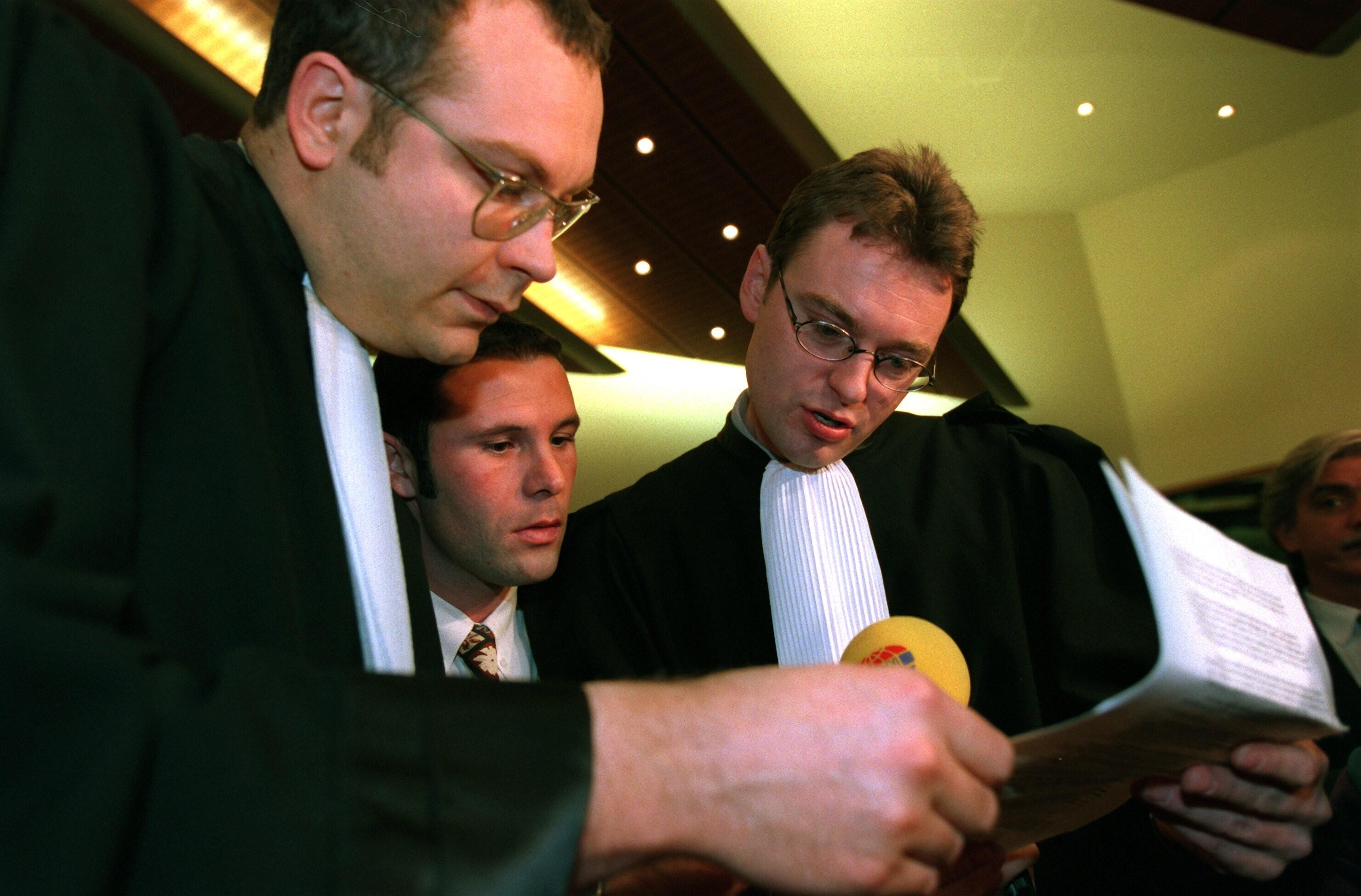 Vor der Urteilsverkündung stecken der belgische Fußball-Profi Jean-Marc Bosman (m) und zwei seiner Anwälte, Marc Lucan (l) und Jean-Claude Dupont die Köpfe zusammen.