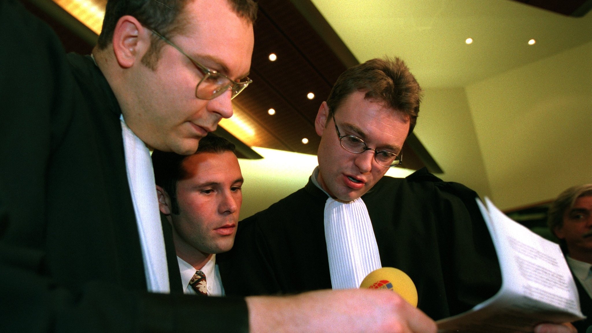 Vor der Urteilsverkündung stecken der belgische Fußball-Profi Jean-Marc Bosman (m) und zwei seiner Anwälte, Marc Lucan (l) und Jean-Claude Dupont die Köpfe zusammen.