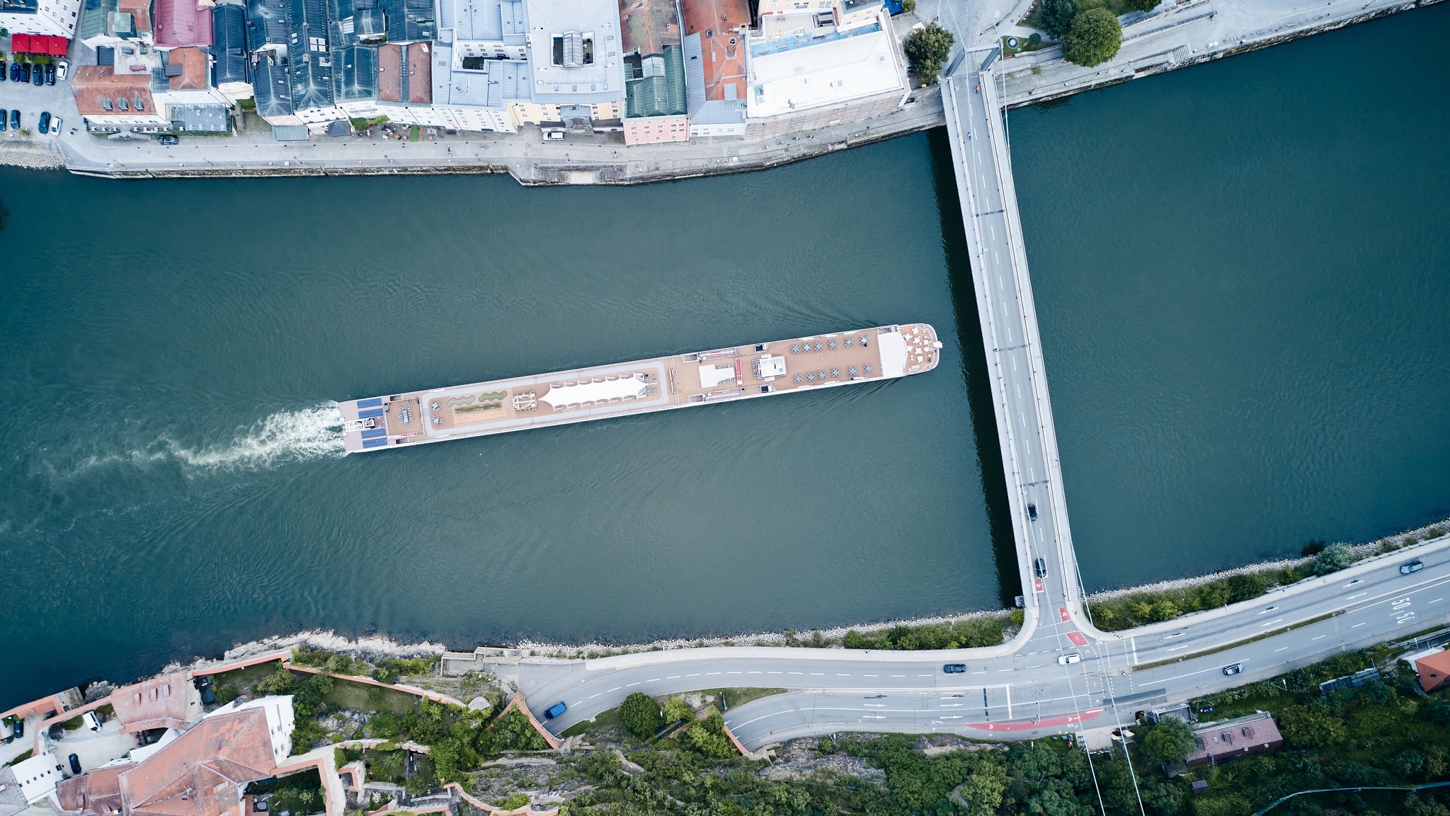 Ein Flusskreuzfahrtschiff fährt stromaufwärts an Passau vorbei