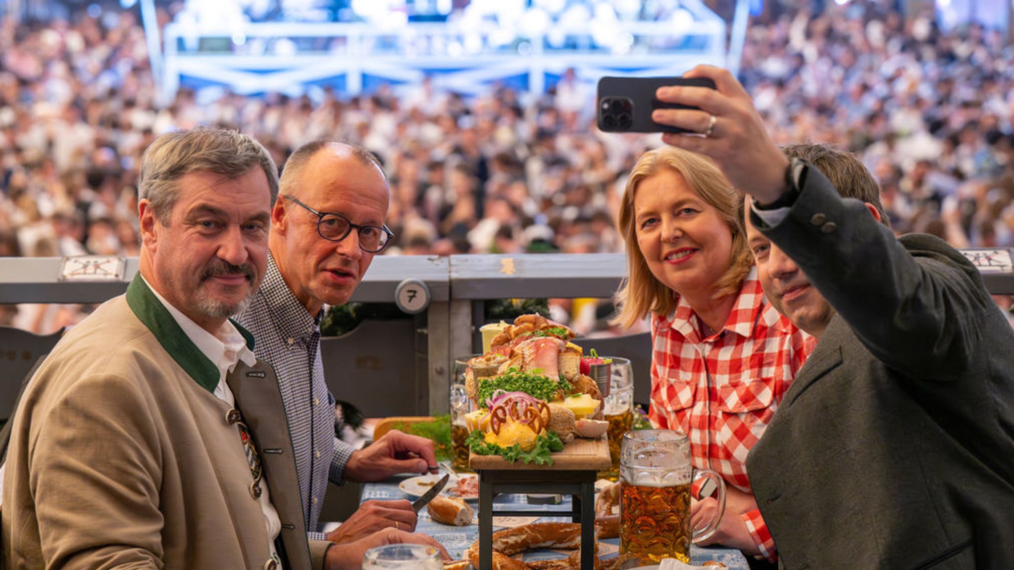 München: Bundeskanzler Friedrich Merz (2.v.l., CDU), Bärbel Bas, Bundesministerin für Arbeit und Soziales und Co-Parteivorsitzende der SPD, und Lars Klingbeil (r, SPD), Vizekanzler und Bundesminister der Finanzen, besuchen auf Einladung von Markus Söder (CSU, l), Ministerpräsident von Bayern, das 190. Oktoberfest und sitzen im Festzelt Schottenhamel. Lars Klingbeil macht ein Selfie der Gruppe. | Bild: dpa-Bildfunk/Peter Kneffel München: Bundeskanzler Friedrich Merz (2.v.l., CDU), Bärbel Bas, Bundesministerin für Arbeit und Soziales und Co-Parteivorsitzende der SPD, und Lars Klingbeil (r, SPD), Vizekanzler und Bundesminister der Finanzen, besuchen auf Einladung von Markus Söder (CSU, l), Ministerpräsident von Bayern, das 190. Oktoberfest und sitzen im Festzelt Schottenhamel. Lars Klingbeil macht ein Selfie der Gruppe.