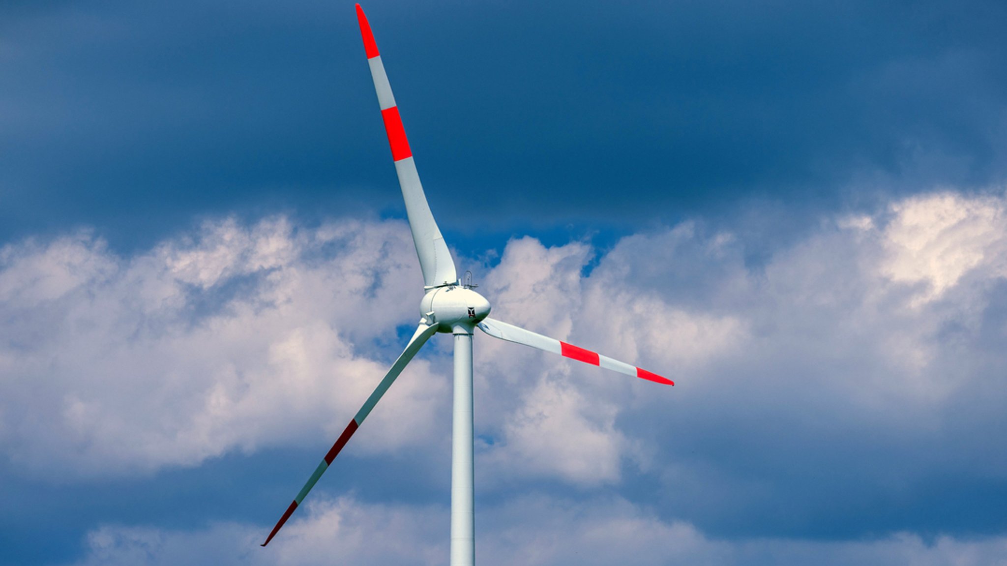 Eine Windkraftanlage dreht sich in einem Windpark.