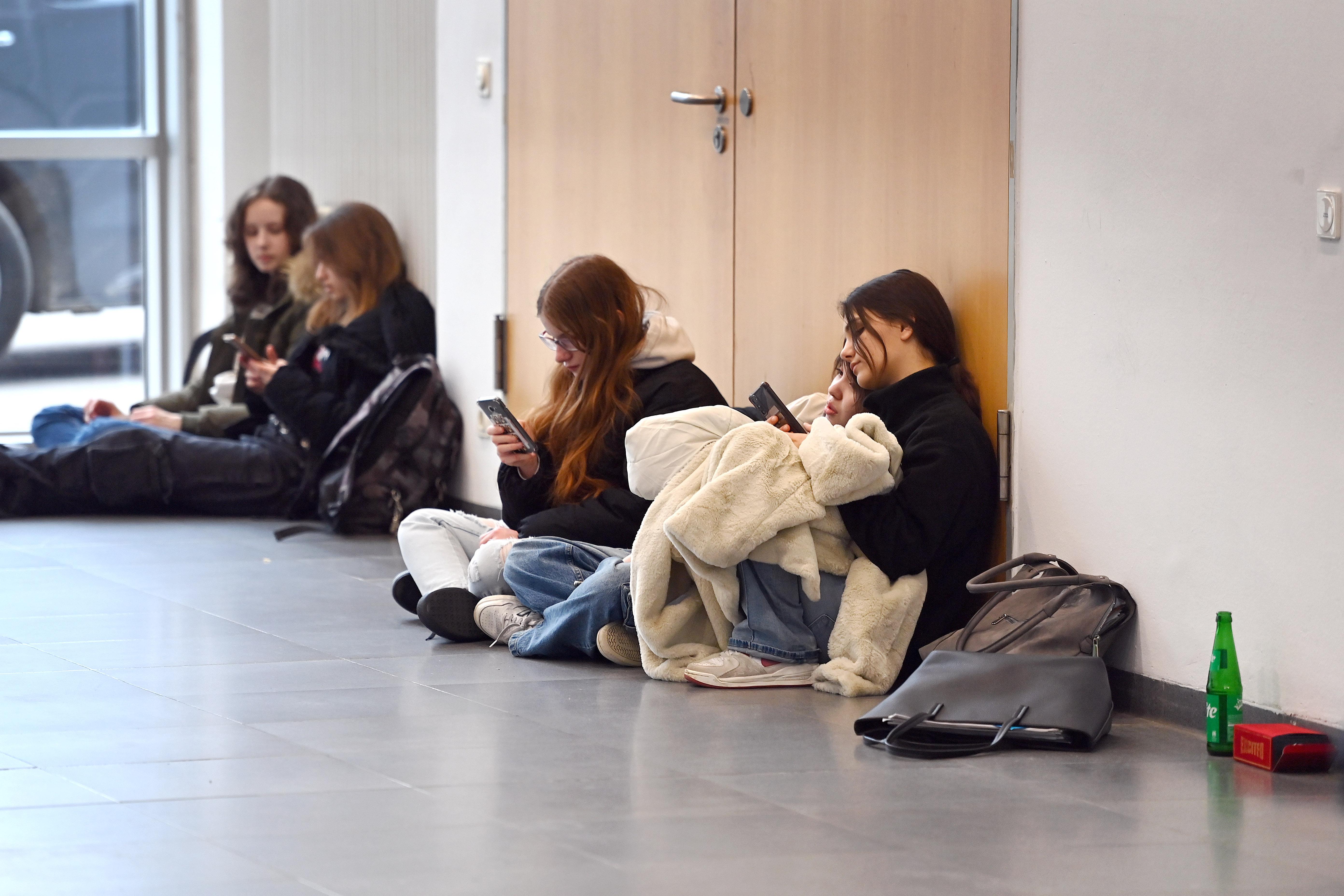 Symbolbild: Jugendliche sitzen am Boden und schauen auf ihre Handys 