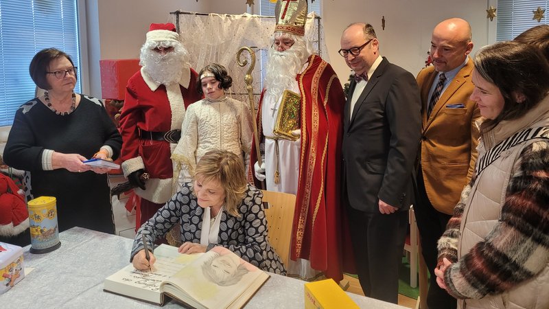 Die Sängerin Nicki unterschreibt im Goldenen Buch von Himmelstadt. Die langjährige Leiterin des Weihnachtspostamts, Rosemarie Schotte (im Bild links), folgte. 