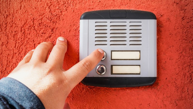 Eine Hand, die an einer Tür klingelt | Bild: stock.adobe.com/mirsad Eine Hand, die an einer Tür klingelt