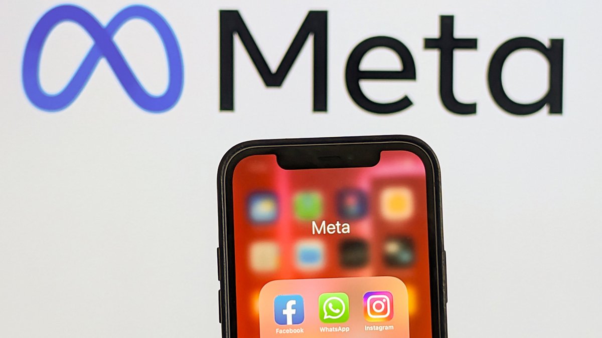Smartphone-Bildschirm mit den Logos von Facebook, WhatsApp, Instagram. Im Hintergrund das Meta-Logo.