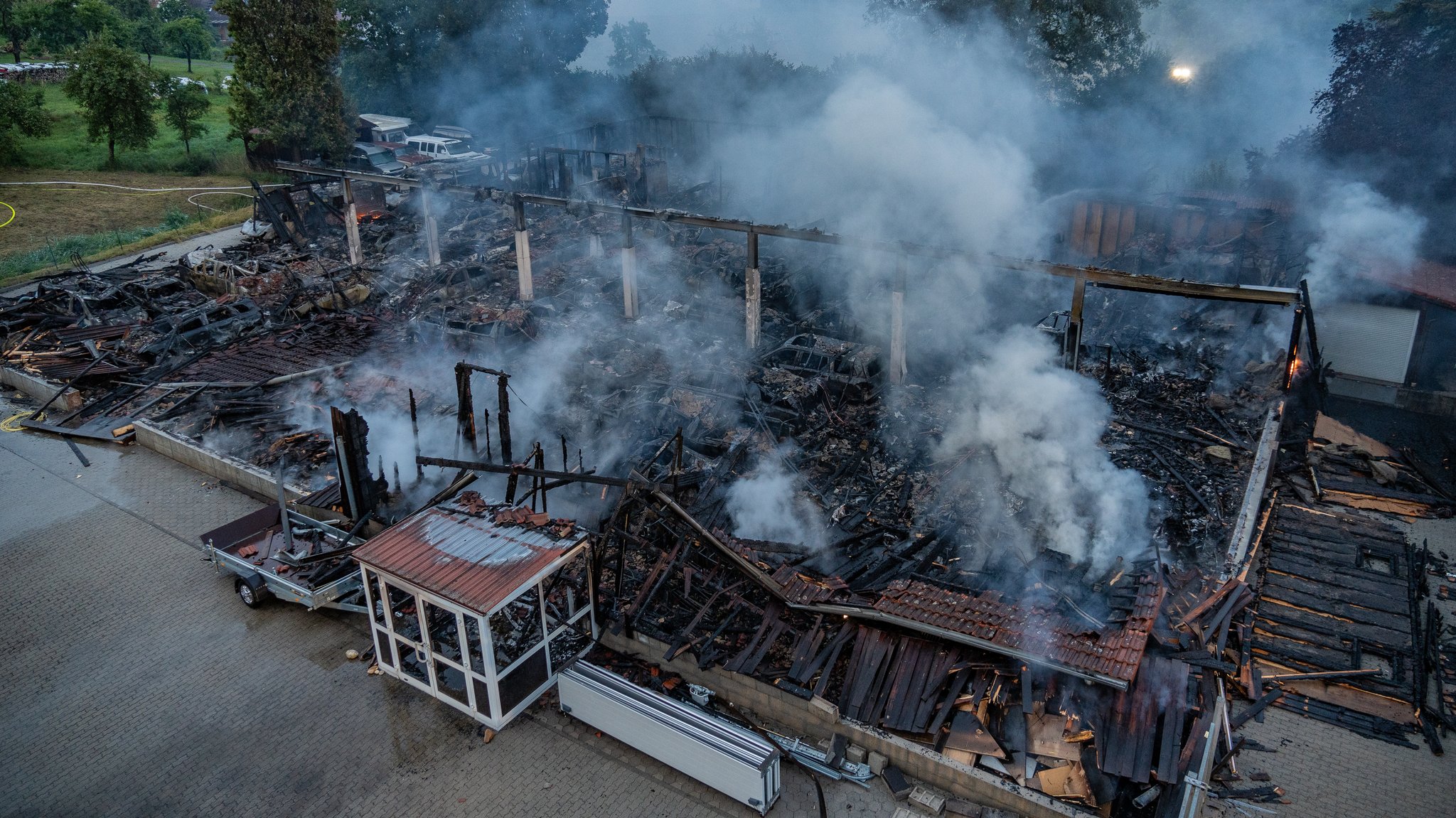 Rauch über der abgebrannten und gelöschten Lagerhalle in Untermerzbach