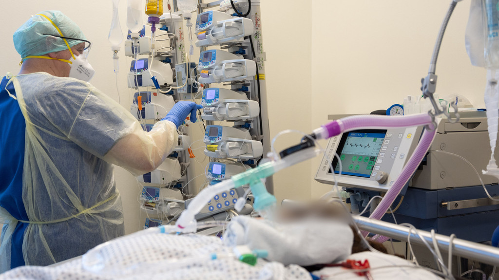 Ein Krankenpfleger versorgt einen schwer an Corona erkrankten Patienten auf der Intensivstation von einem Krankenhaus