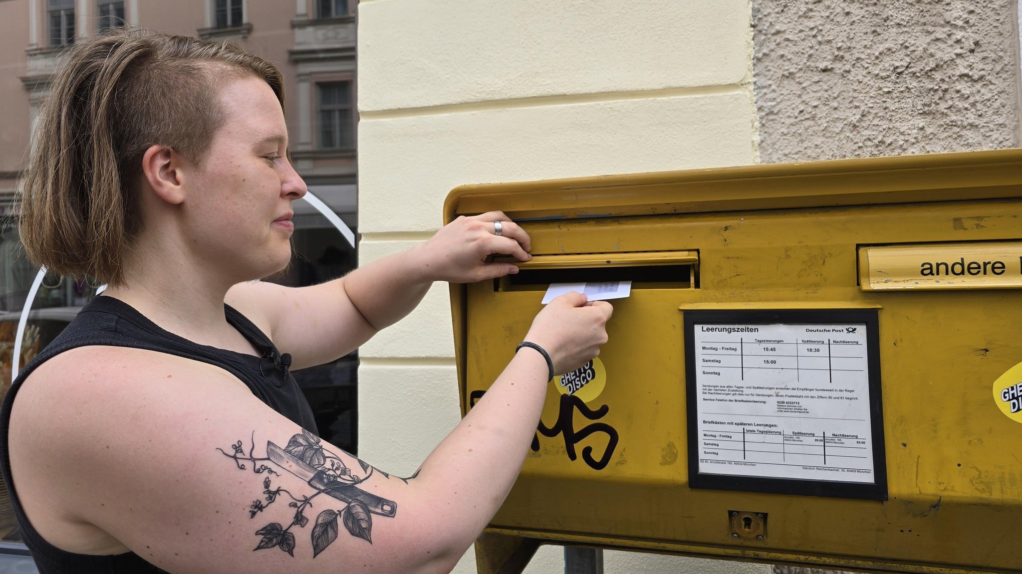 Zu sehen ist eine Person, die einen Brief einwirft. 