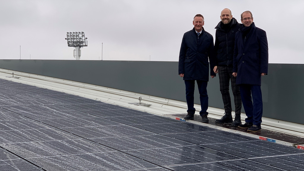 Fürths Oberbürgermeister Thomas Jung (SPD) auf Stadiondach vor einer Photovoltaik-Anlage.
