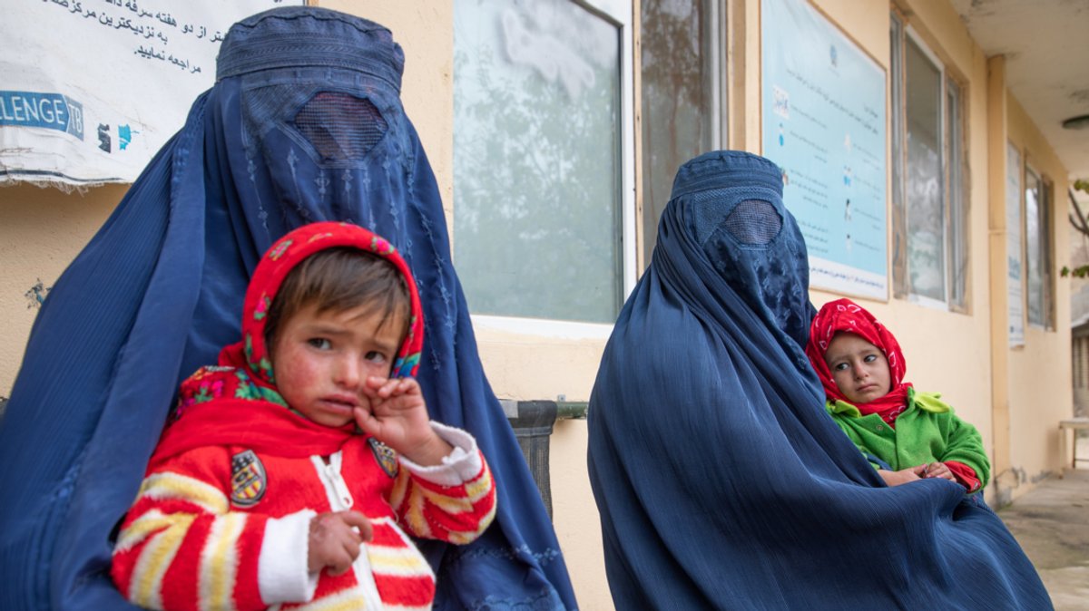 Afghanistan, Aqkoprok: Zwei afghanische Frauen warten mit ihren Kindern vor einer Klinik für Ernährungsfragen.
