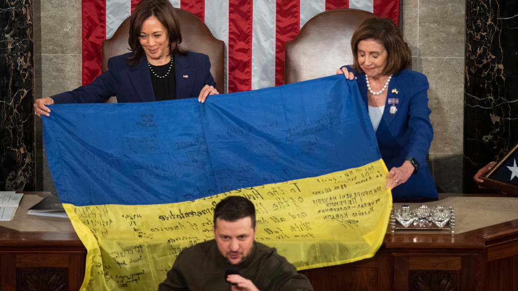 Bei seiner Rede vor den beiden Parlamentskammern überreichte er der Vorsitzenden des US-Repräsentantenhauses, Nancy Pelosi, eine Fahne, die von ukrainischen Soldaten aus der Frontstadt Bachmut, die Selenskyi am Tag zuvor besucht hatte. | Bild: picture alliance / Consolidated News Photos | Cliff Owen - CNP Bei seiner Rede vor den beiden Parlamentskammern überreichte er der Vorsitzenden des US-Repräsentantenhauses, Nancy Pelosi, eine Fahne, die von ukrainischen Soldaten aus der Frontstadt Bachmut, die Selenskyi am Tag zuvor besucht hatte.