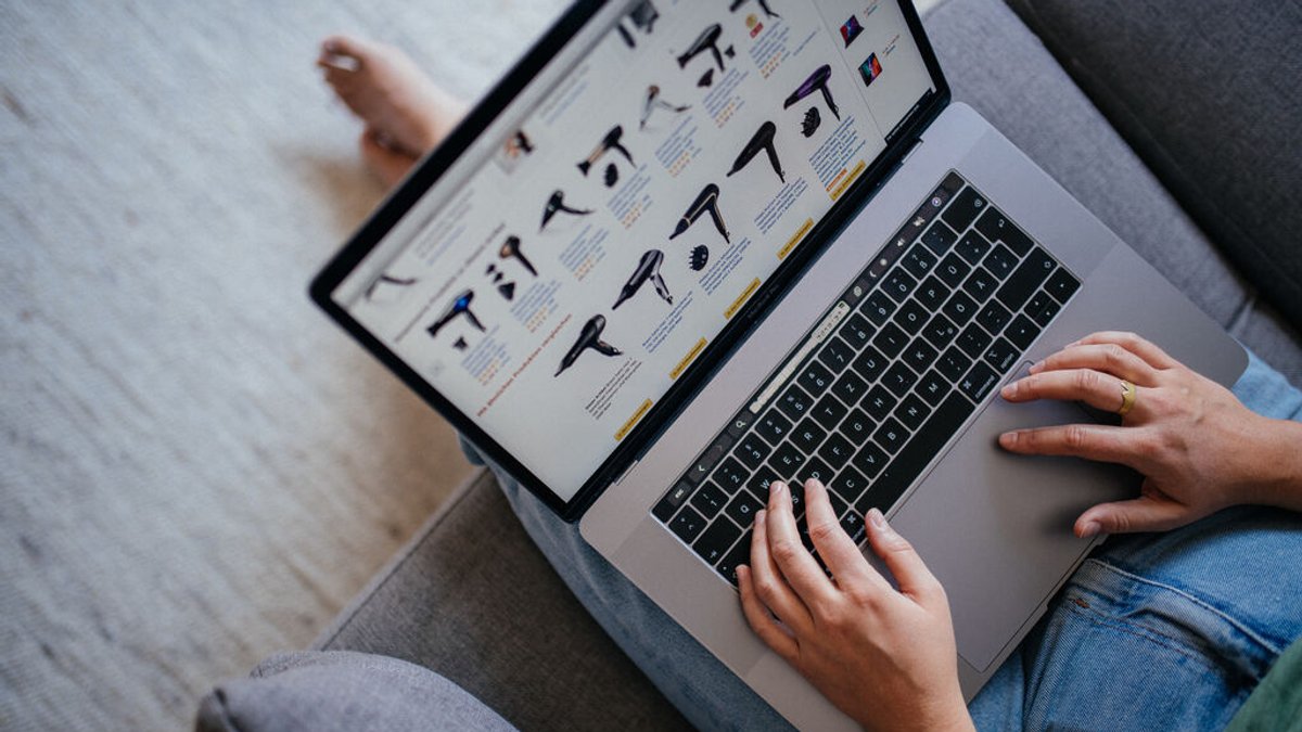 Eine Frau sitzt am Laptop und shoppt online.