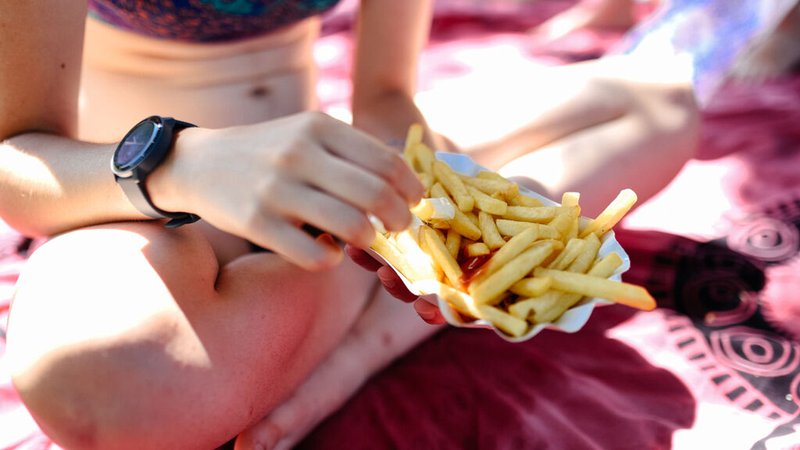 Ein Mädchen hält Pommes im Schwimmbad in der Hand. | Bild: BR/Julia Müller Ein Mädchen hält Pommes im Schwimmbad in der Hand.