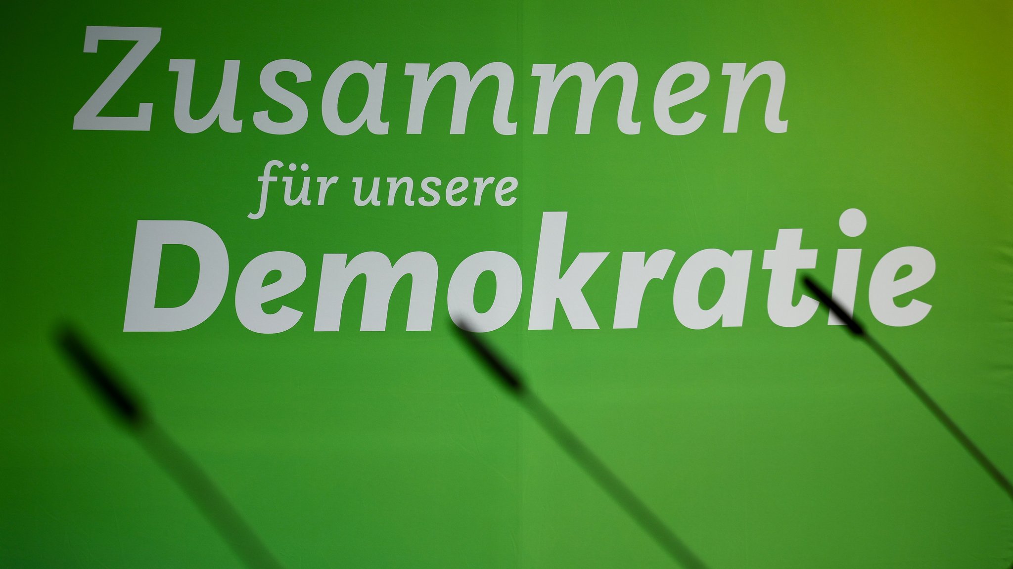 Der Schriftzug "Zusammen für unsere Demokratie" hängt an einer Wand vor der Pressekonferenz zum Auftakt der Klausurtagung der Bundestagsabgeordneten der Grünen.