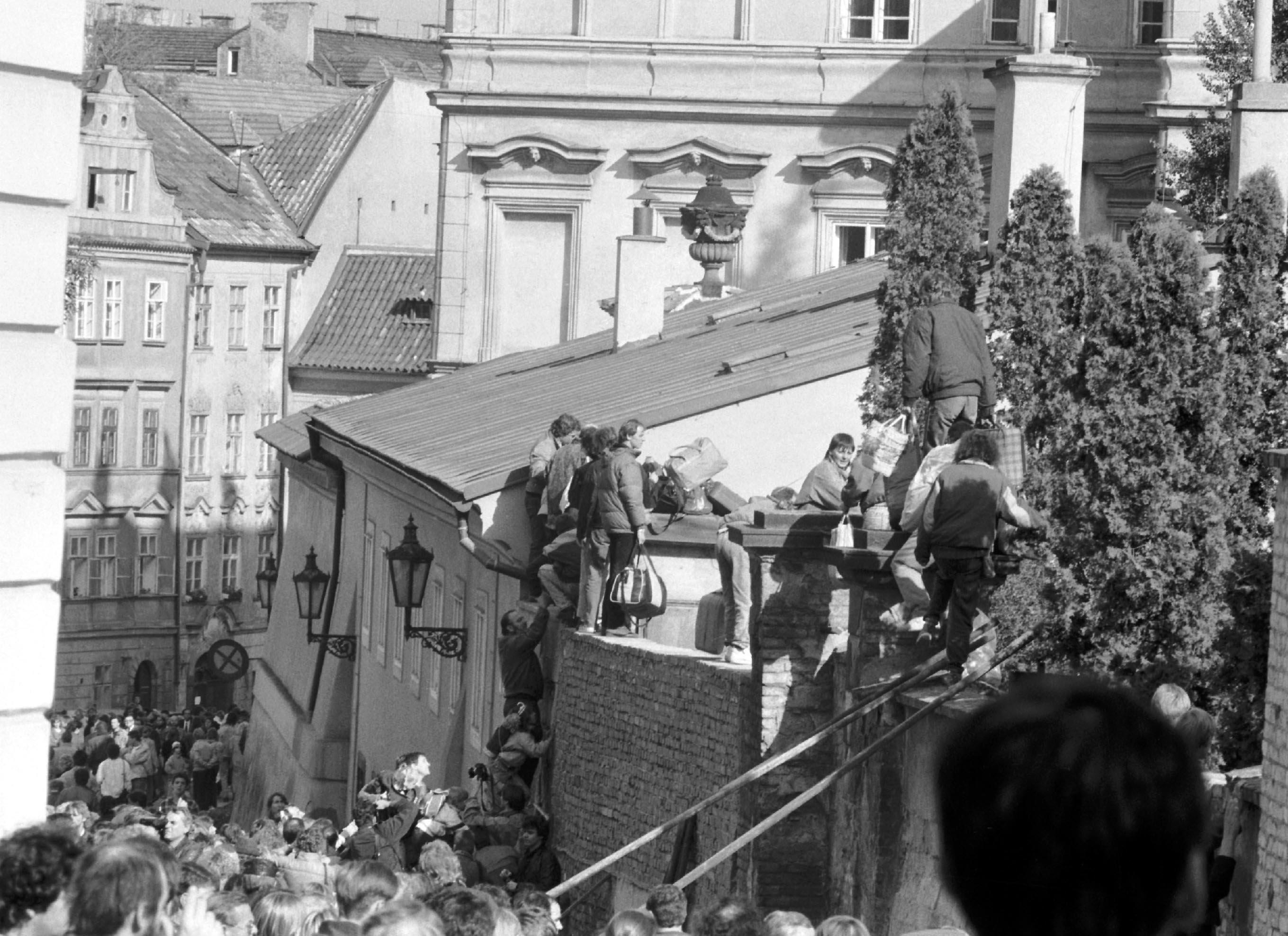 Ausreisewillige DDR-Bürger klettern im September 1989 über eine Mauer auf das Gelände der bundesdeutschen Botschaft in der tschechoslowakischen Hauptstadt Prag.
