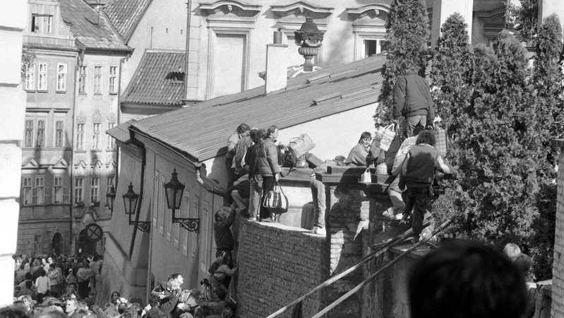 Ausreisewillige DDR-Bürger klettern im September 1989 über eine Mauer auf das Gelände der bundesdeutschen Botschaft in der tschechoslowakischen Hauptstadt Prag.