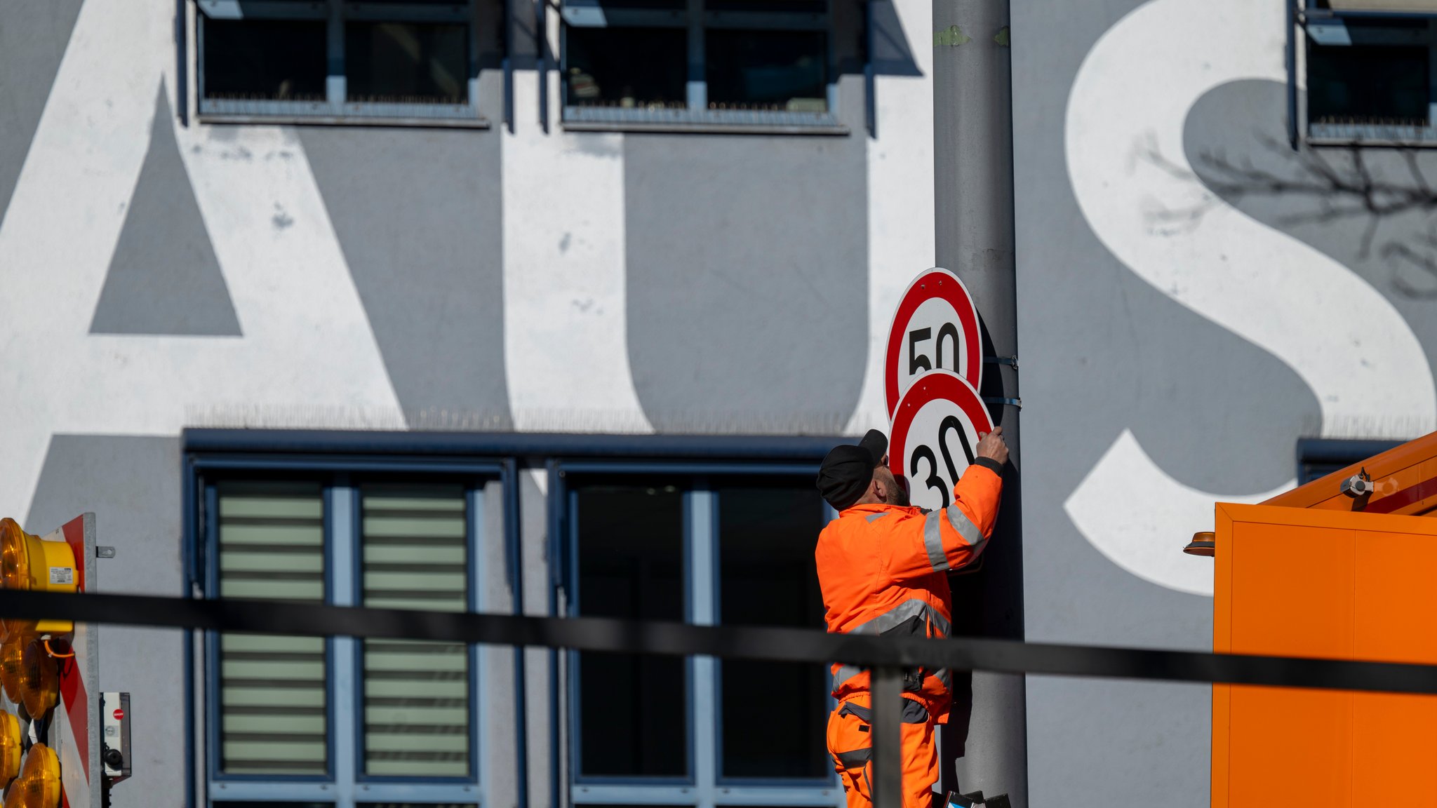 Ein Arbeiter montiert ein Tempo-30-Schild an der Landshuter Allee an. 