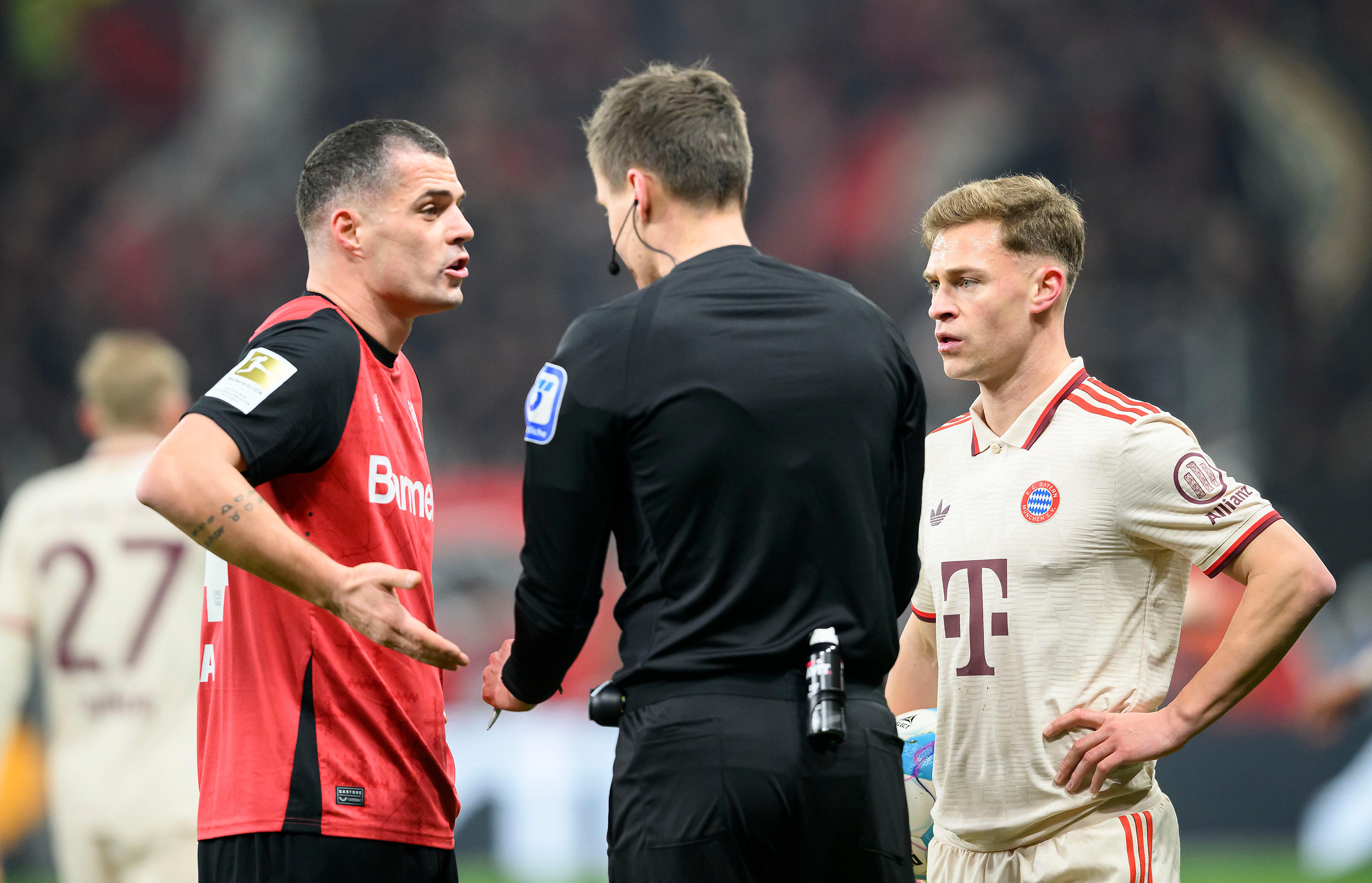 Leverkusens Granit Xhaka (links) und FC Bayerns Joshua Kimmich im Gespräch mit dem Schiedsrichter.