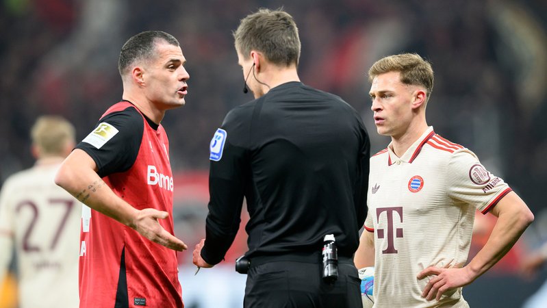 Leverkusens Granit Xhaka (links) und FC Bayerns Joshua Kimmich im Gespräch mit dem Schiedsrichter. | Bild: picture alliance / SVEN SIMON Leverkusens Granit Xhaka (links) und FC Bayerns Joshua Kimmich im Gespräch mit dem Schiedsrichter.