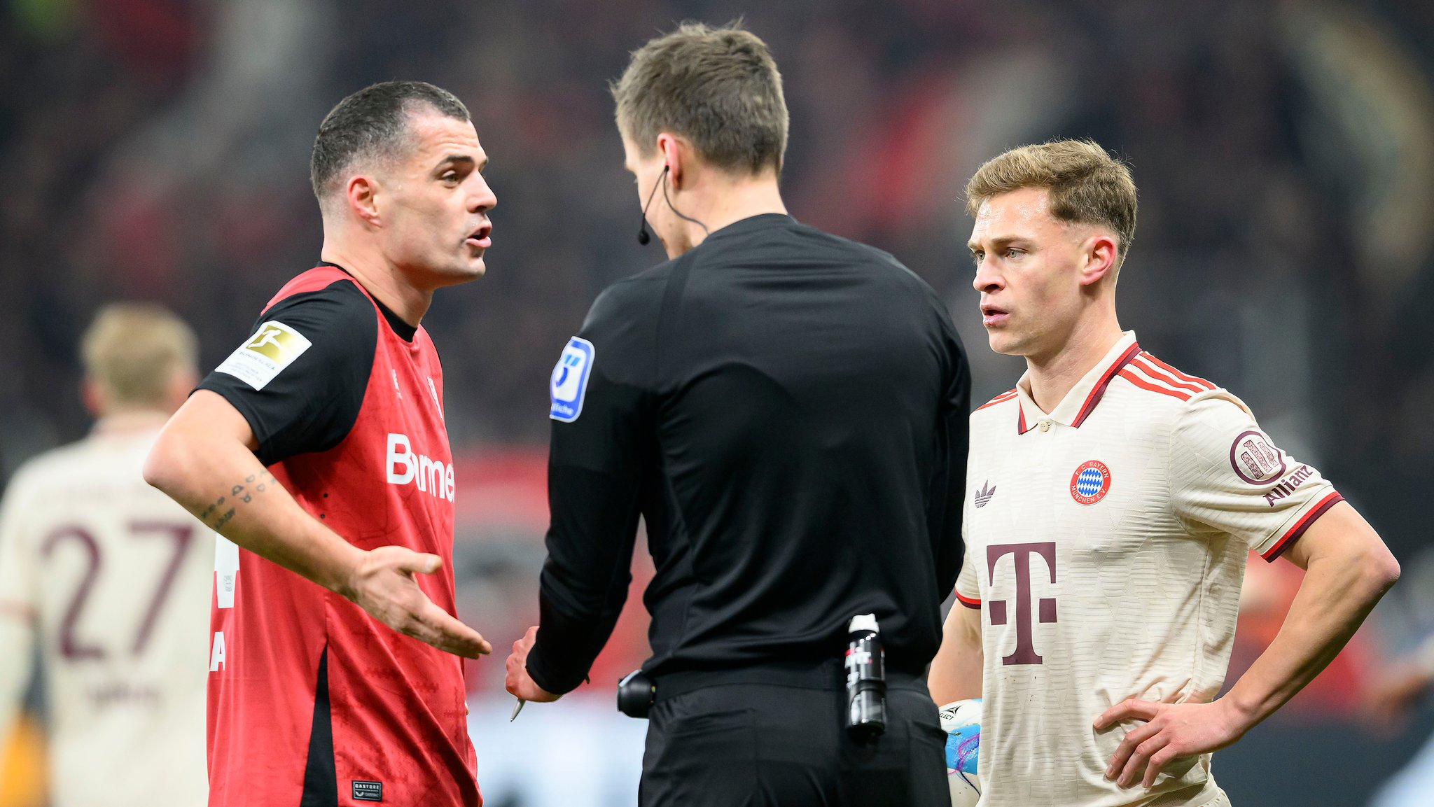 Leverkusens Granit Xhaka (links) und FC Bayerns Joshua Kimmich im Gespräch mit dem Schiedsrichter.