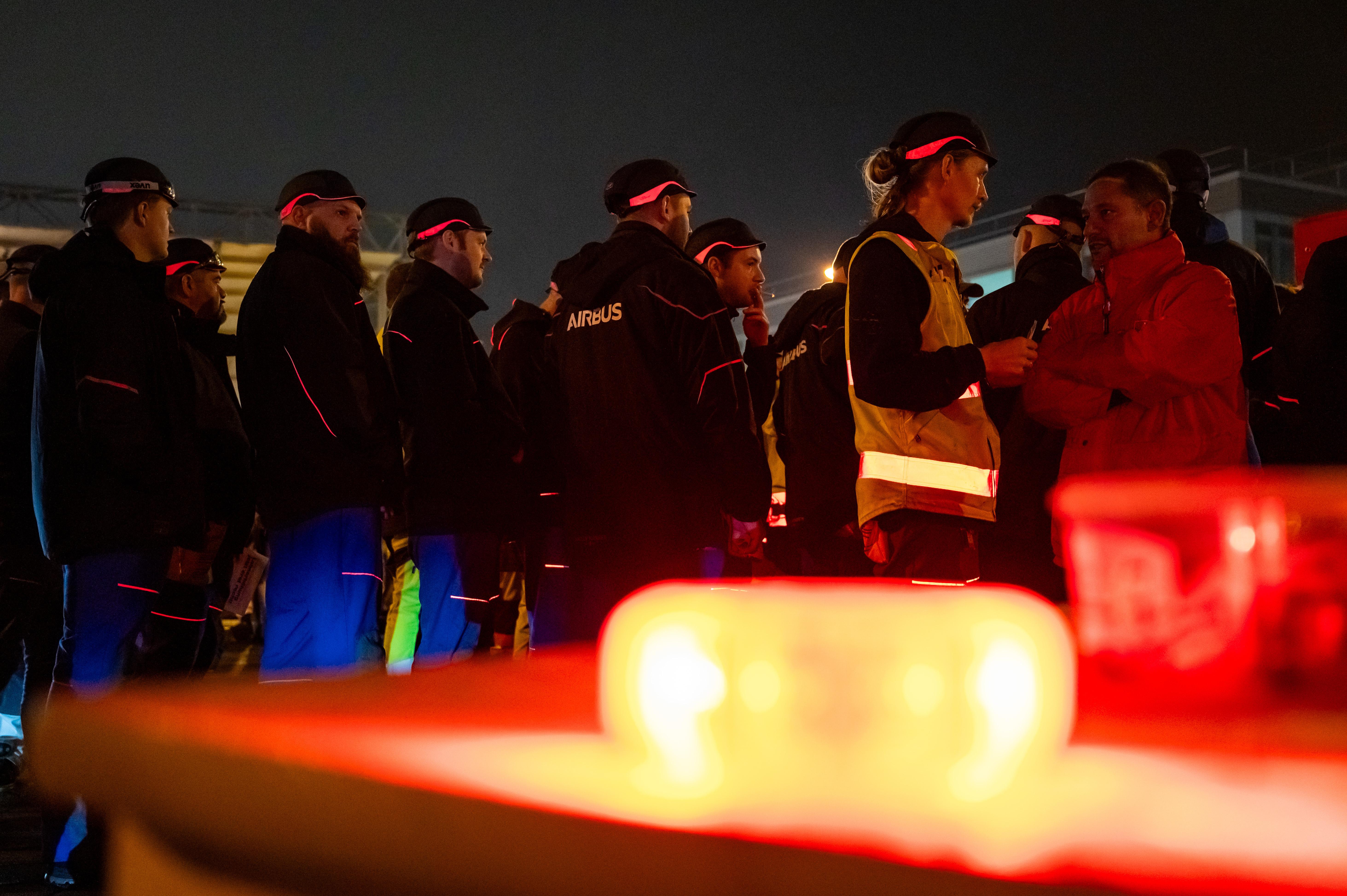 Streikende stehen vor dem Werksgelände von Airbus in Finkenwerder.