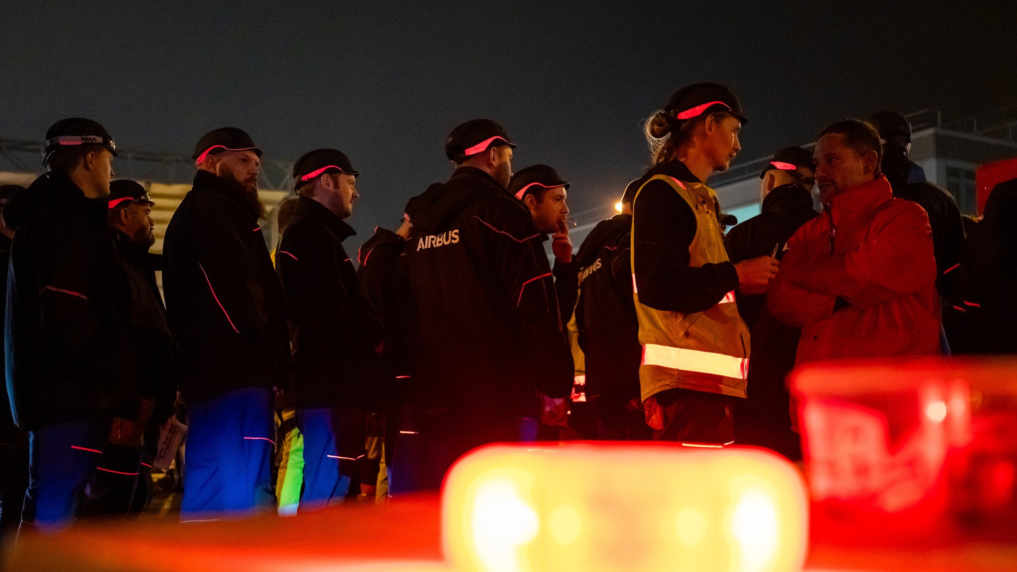 Streikende stehen vor dem Werksgelände von Airbus in Finkenwerder.