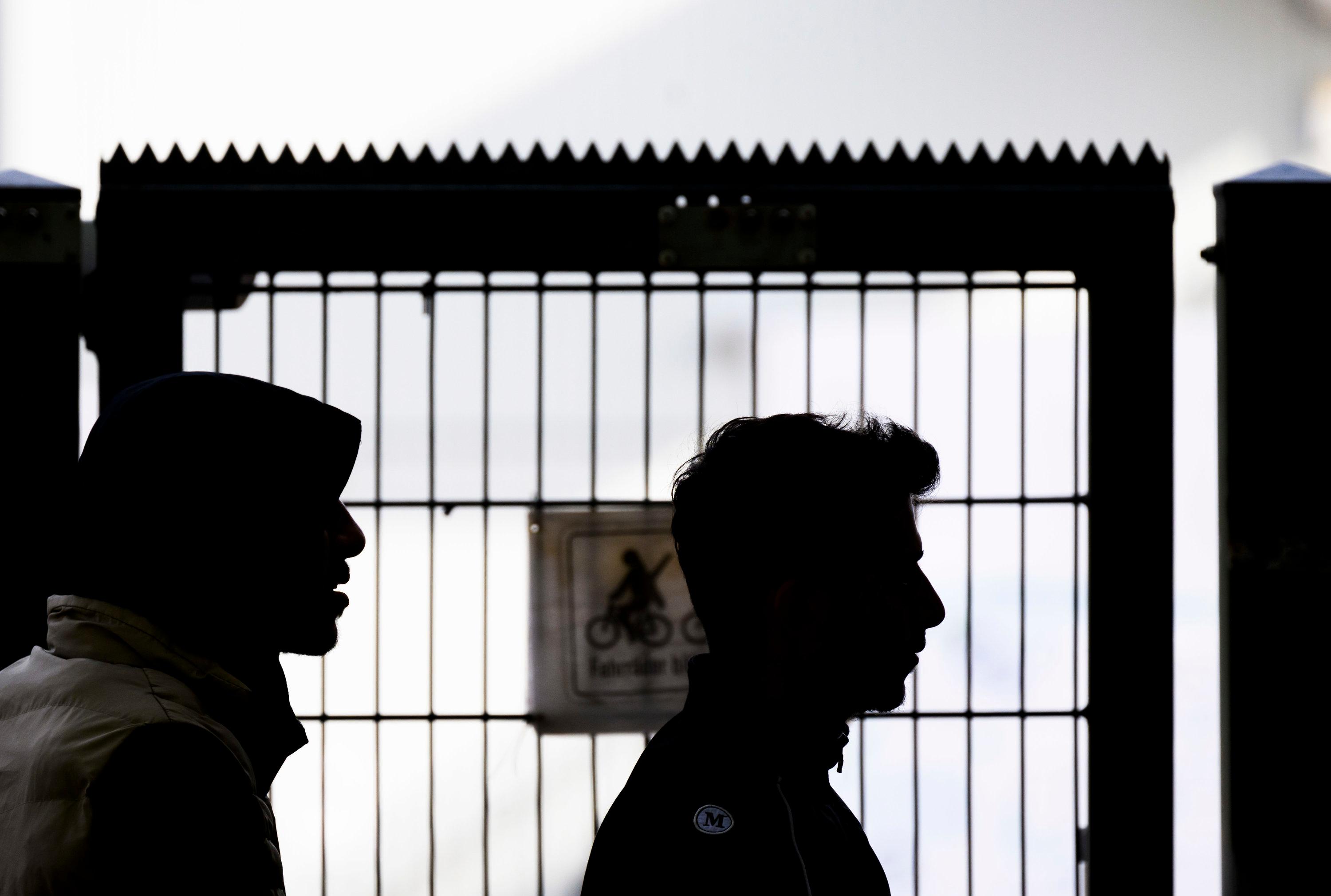 Zwei Männer stehen am Eingangstor der Landesaufnahmebehörde Niedersachsen am Standort Braunschweig (Symbolbild)