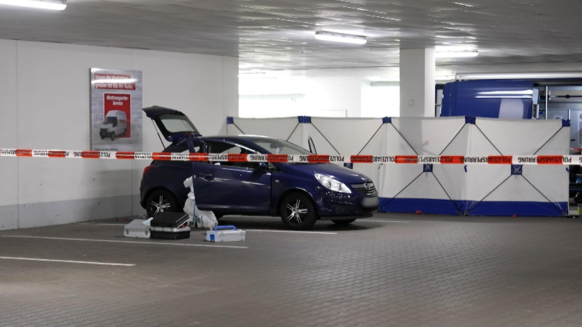 Ein Kleinwagen steht in einer Tiefgarage hinter einem Absperrband der Polizei.