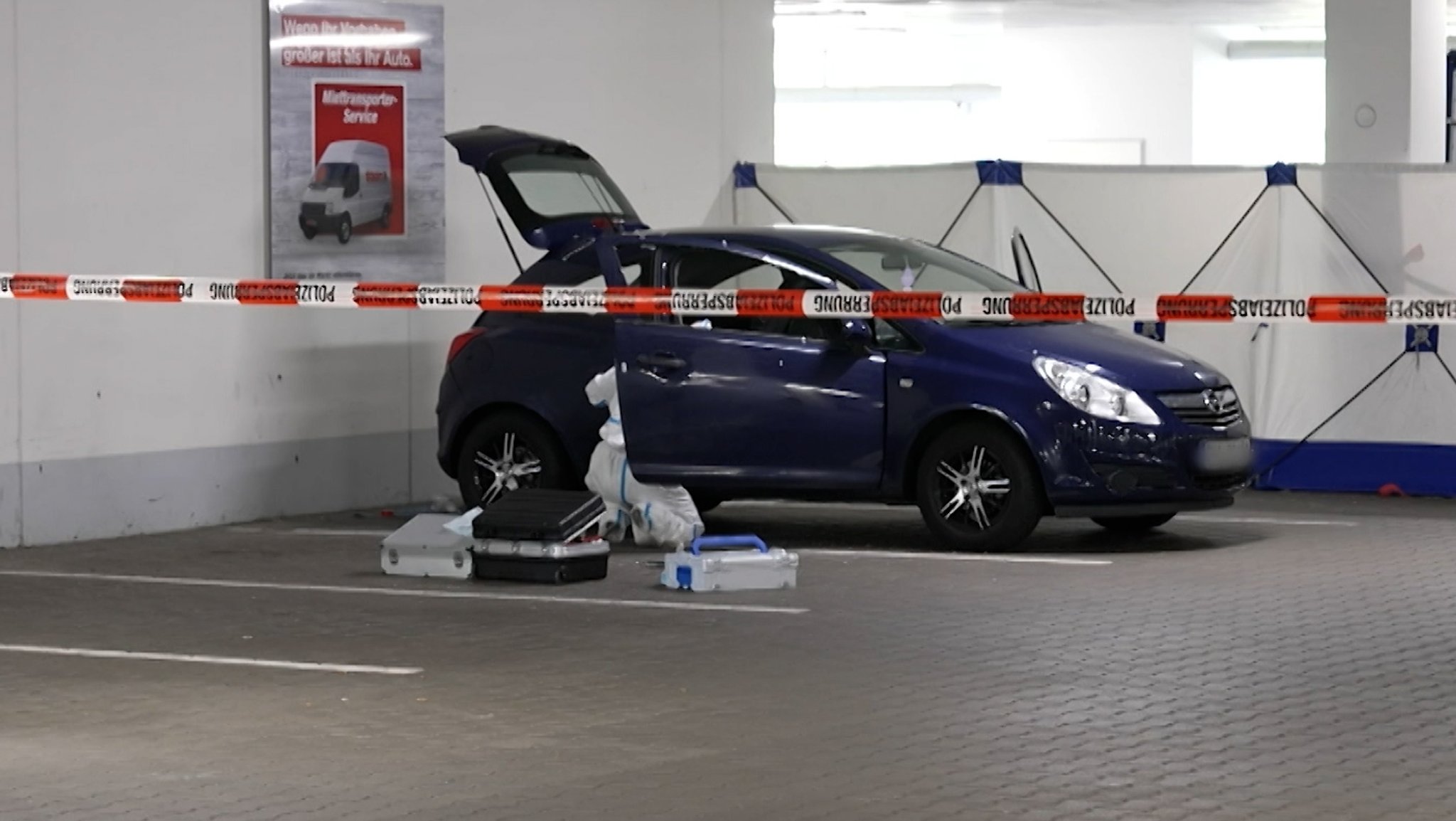 Ein Kleinwagen steht in einer Tiefgarage hinter einem Absperrband der Polizei.