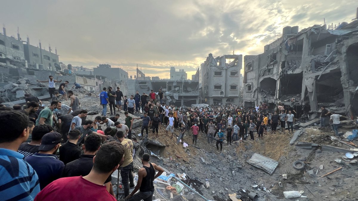 Palästinenser suchen nach Opfern unter den Trümmern eines zerstörten Gebäudes.