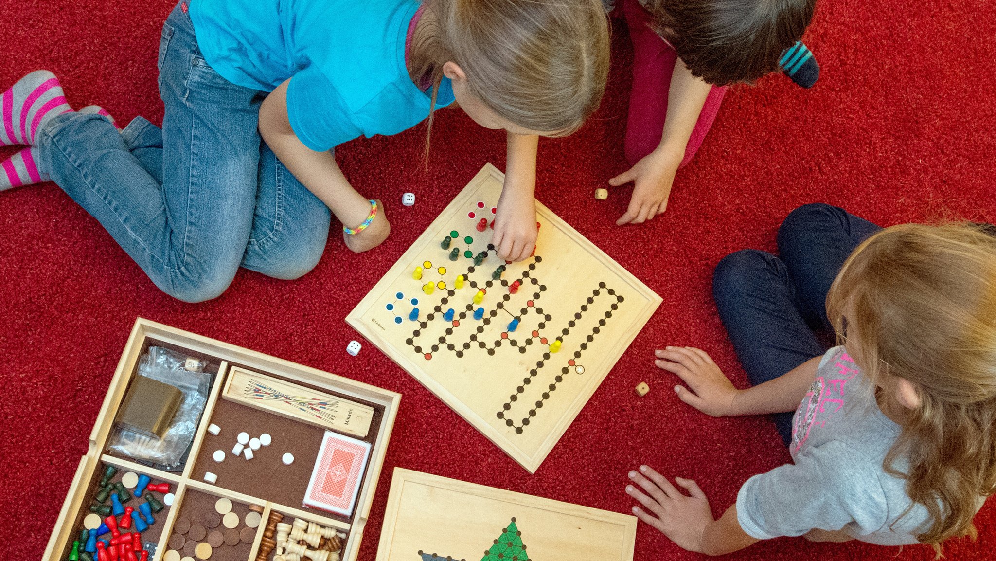 Drei Kinder spielen Malefiz